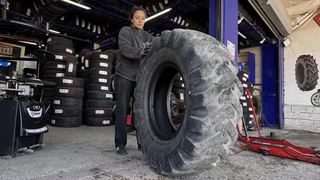 Sahada top koşturan genç kız, oto lastik dükkanında da babasına yardımcı oluyor